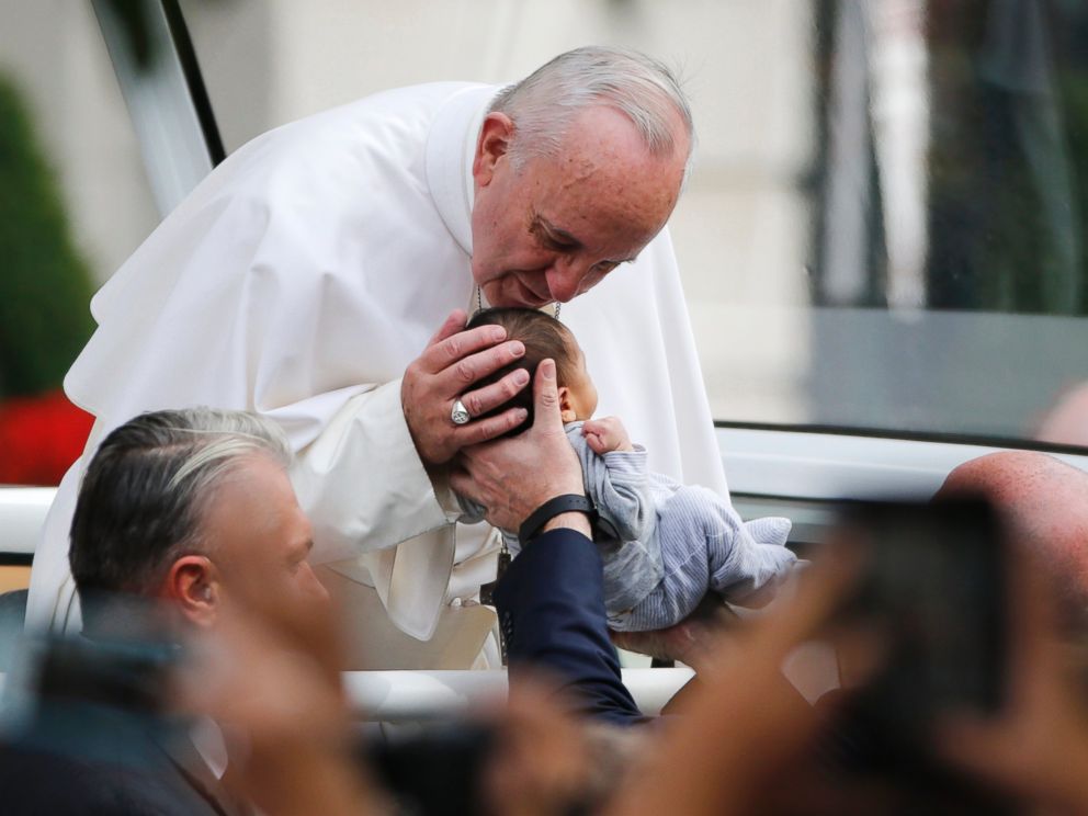 PHOTO: Pope Francis passes the crowd and kisses a baby in his pope mobile in Philadelphia on Saturday, Sept. 26, 2015.