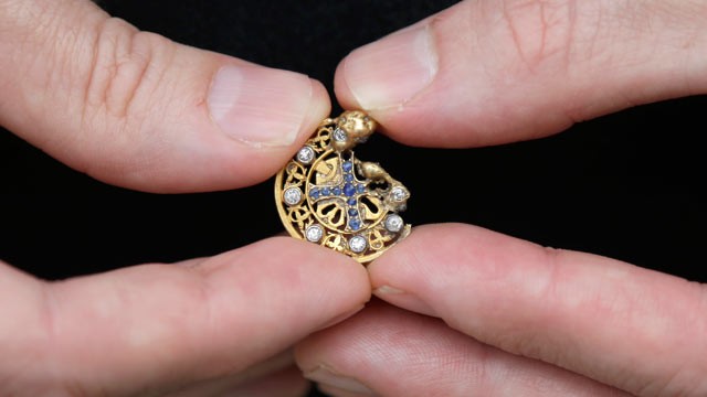PHOTO: Mark Rubinstein holds a gold pendant with sapphires forming a cross inside a circle of diamonds, that he found while python hunting in the Florida Everglades, May 31, 2013.