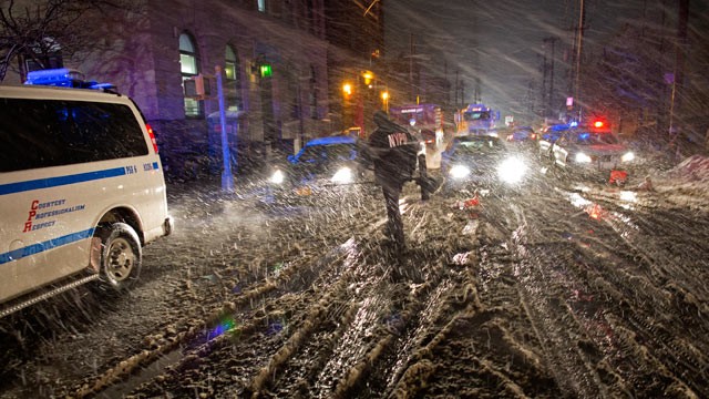 PHOTO: A member of the New York Police Department walks through snow as it accumulates in the Rockaway Beach neighborhood of the borough of Queens, New York, Nov. 7, 2012.