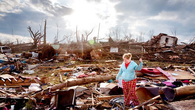 PHOTO: A resident of Henryville, Ind. looks through the debris on March 4, 2012, after a tornado destroyed her home.
