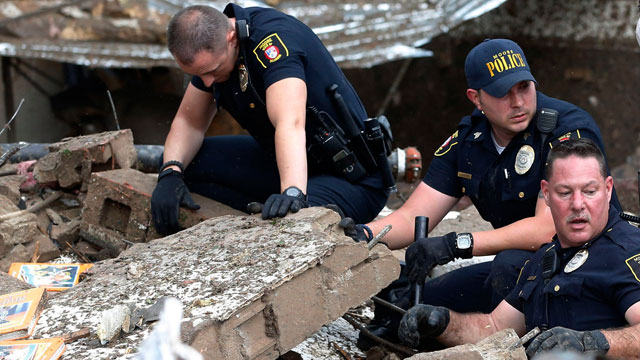 PHOTO: Moore police dig through the rubble of the Plaza Towers Elementary School following a tornado in Moore, Okla., May 20, 2013.