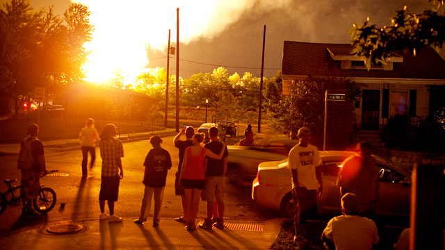 PHOTO: People watch the flames shoot up from a freight train that derailed, early July 11, 2012 in Columbus Ohio.