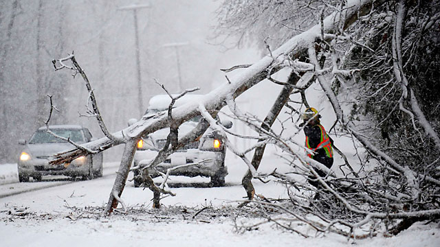 PHOTO: Volunteers remove a downed tree on the road near Chancellorsville, Va. A snowstorm blanketed the Fredericksburg region, March 6, 2013, closing schools, county governments and roads.