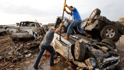PHOTO: Two men attempt  to pry open a door on this car to check for victims in a business parking lot west of I-35 south of 4th Street  in Moore, on  May 20, 2013.