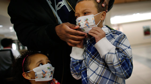 PHOTO: Damien Dancy puts masks on his children Damaya, 3, left, and Damien, 7, on Wednesday, Jan. 9, 2013 at Sentara Princess Anne Hospital in Virginia Beach, Va.