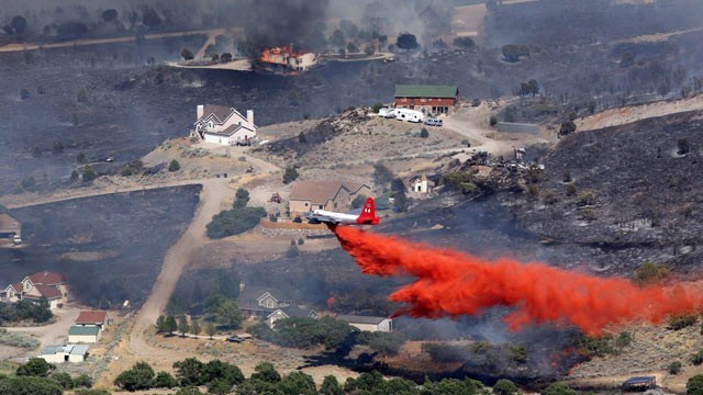 PHOTO: An air tanker drops retardant on a fire after it engulfed homes in the Rose Canyon area of Herriman, Utah, June 29, 2012.