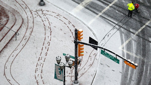 PHOTO: A person pushes a cart to spread salt on a snowy sidewalk at Military Park in downtown Newark, N.J. on Dec. 26, 2012.