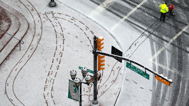 PHOTO: A person pushes a cart to spread salt on a snowy sidewalk at Military Park in downtown Newark, N.J. on Dec. 26, 2012.