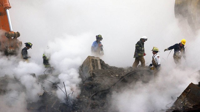PHOTO: In this Oct. 11, 2001 file photo, firefighters make their way over the ruins and through clouds of smoke at the World Trade Center in New York.