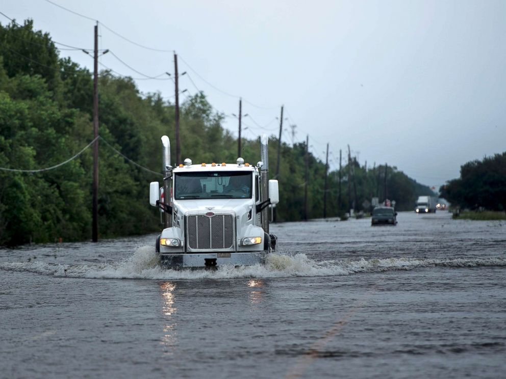 PHOTO: Trucks make their way through flood waters on a main road leading to the Arkema Inc. chemical plant that was in crisis during the aftermath of Hurricane Harvey, Aug. 30, 2017, in Crosby, Texas.