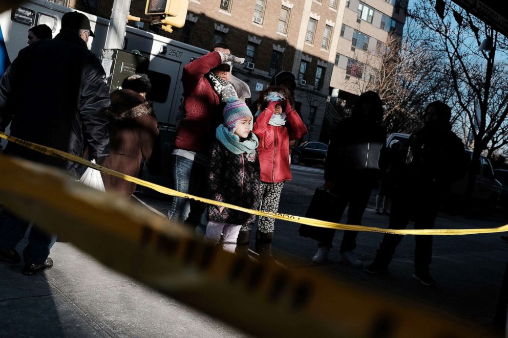 PHOTO: People look at the apartment building where a deadly fire took the lives of 12 people in the Bronx borough of New York, Dec. 29, 2017.
