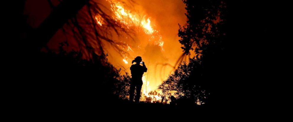 PHOTO: A firefighter takes a cell phone picture during a wildfire, Dec. 16, 2017, in Montecito, Calif. 