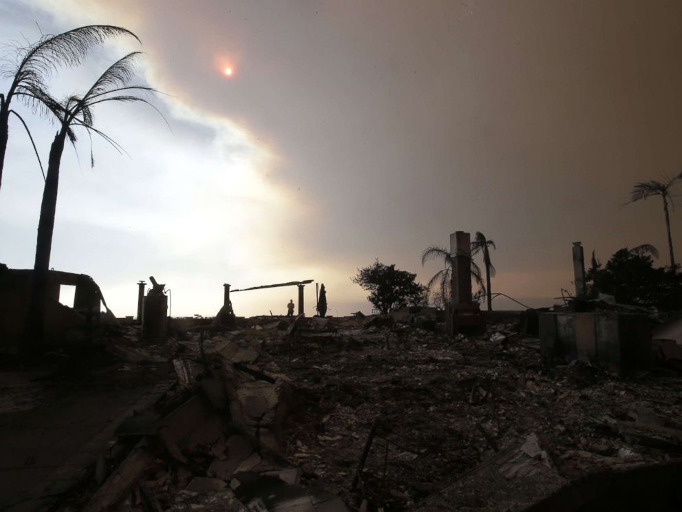 PHOTO: A man walks among the ruins of a home destroyed by the Thomas Fire as smoke obscures the sky in Ventura, Calif., Dec. 6, 2017.