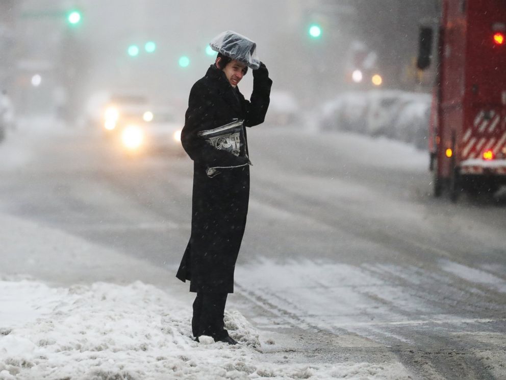 PHOTO: A man holds his hat in strong winds and falling snow in New York, March 14, 2017.