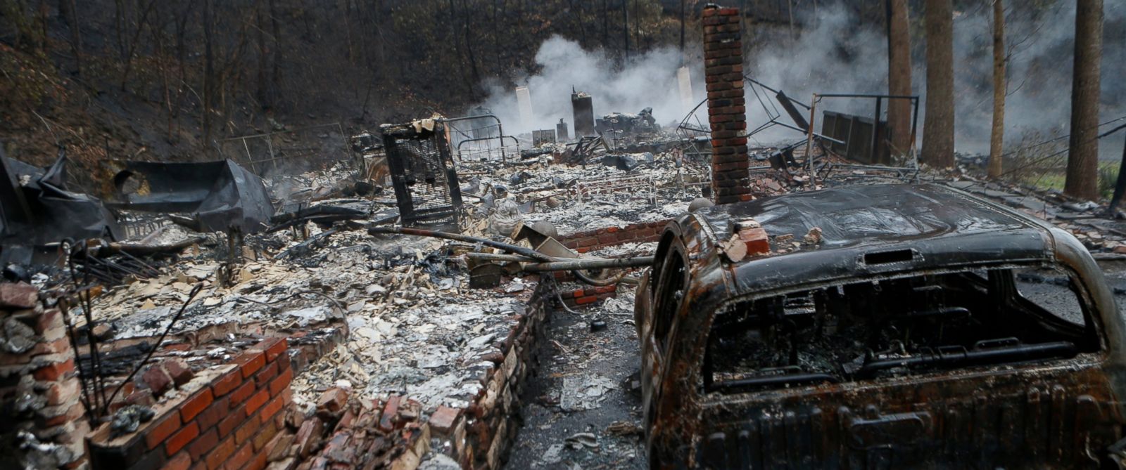 PHOTO: The remains of a home smolder in the wake of a wildfire, Nov. 30, 2016, in Gatlinburg, Tennessee.