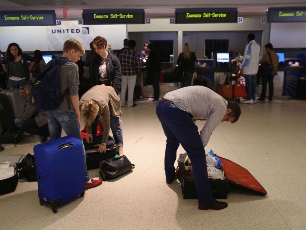 Passengers repack luggage before it is screened at a new explosives detection system at the Newark Liberty International Airport on May 1, 2014. 