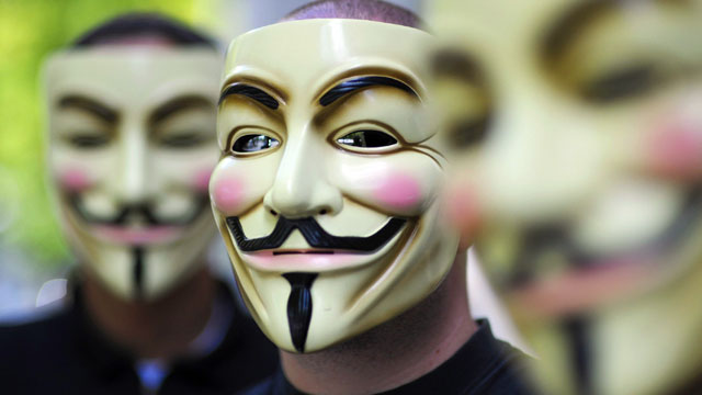 PHOTO: Activists of the organization "Anonymous" hold masks in front of their faces during a demonstration in Berlin.