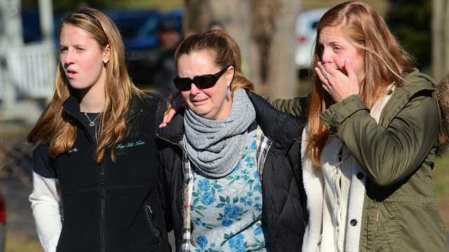 PHOTO: Residents leave after paying a flower tribute to the victims of an elementary school shooting in Newtown, Ct., Dec. 15, 2012.