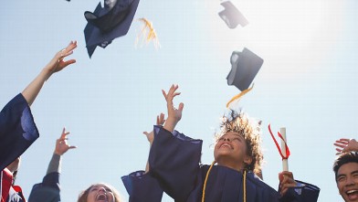 PHOTO: High school graduates are seen tossing caps into the air, after their graduation ceremony.
