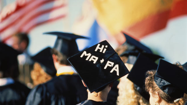 PHOTO: This stock photo of a high school graduation ceremony shows girl with message on mortarboard to her parents.