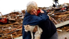 PHOTO: June Simson receives a hug from her neighbor while embracing her cat Sammi after she found him standing on the rubble of her destroyed home, May 21, 2013 in Moore, Okla.
