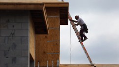 PHOTO: A construction worker climbs on the roof of a home as he helps build a Toll Brothers Inc. home in the Azura community on November 20, 2012 in Boca Raton, Florida.