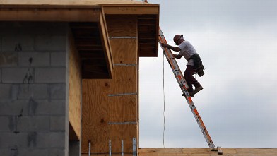 PHOTO: A construction worker climbs on the roof of a home as he helps build a Toll Brothers Inc. home in the Azura community on November 20, 2012 in Boca Raton, Florida.