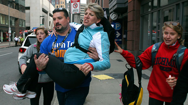 PHOTO: Former New England Patriots player Joe Andruzzi carries a woman from the scene on Exeter Street after two explosions went off near the finish line of the 117th Boston Marathon, April 15, 2013.