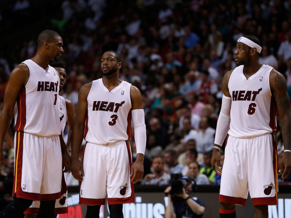 PHOTO: Chris Bosh, Dwyane Wade, and LeBron James of the Miami Heat look on during a game against the Houston Rockets at American Airlines Arena on March 16, 2014 in Miami.