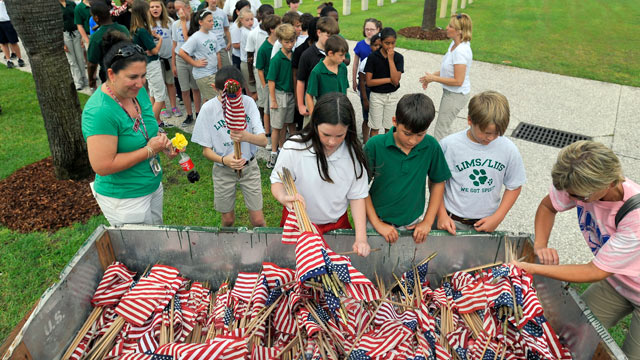 PHOTO: Teachers at Lady's Island Intermediate School hand out American flags to a group of fifth grade students at the Beaufort National Cemetery May 27, 2011 in Beaufort, South Carolina.