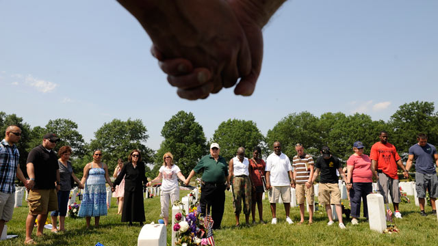 PHOTO: People hold hands during a moment of silence at Arlington National Cemetery on Memorial Day, May 30, 2011 in Arlington, VA.