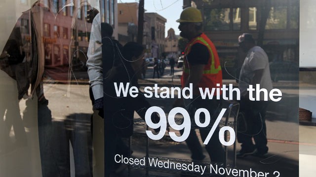 PHOTO: A sign hangs in the window of a Men's Wearhouse store in solidarity with Occupy Oakland's general strike, Oakland, California, Nov. 2, 2011.