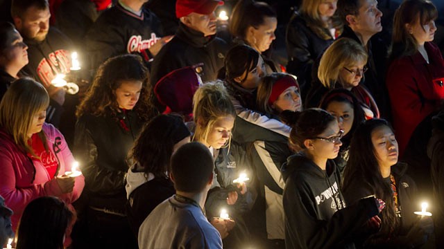 PHOTO: Students and those in the community embrace one another as they hold a candlelight vigil at St Mary's of the Assumption Church.