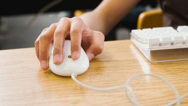 PHOTO: Students hand on computer mouse.