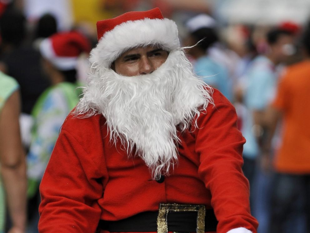 PHOTO: A man dressed as Santa Claus rides his bicycle with other hundreds along the streets of Cali, Colombia, on December 12, 2010 in a failed attempt to break the previous Guinness record of 12,000 people riding bikes dressed as Santa Claus.