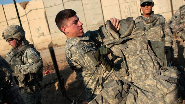 PHOTO: Lt. Andrew Minoski of Las Vegas, Nevada of the U.S. Armys 172nd Brigade Combat Team (C) dons his body armor before a patrol January 19, 2009 in Musayyib, in the Babil Province, Iraq.