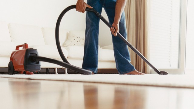 PHOTO: Man vacuuming carpet