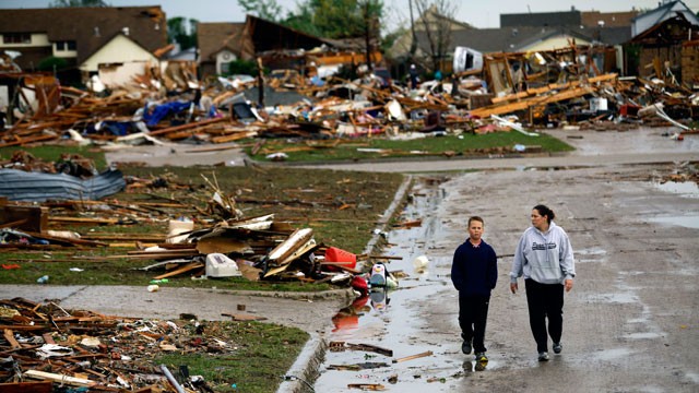 PHOTO: A woman and young boy walk along a street, May 21, 2013, in Moore, Okla.