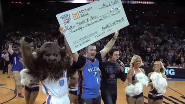 PHOTO: Oklahoma City Thunder fan Heath Kufahl shows his $20,000 check after scoring a half court shot, March 5, 2013.