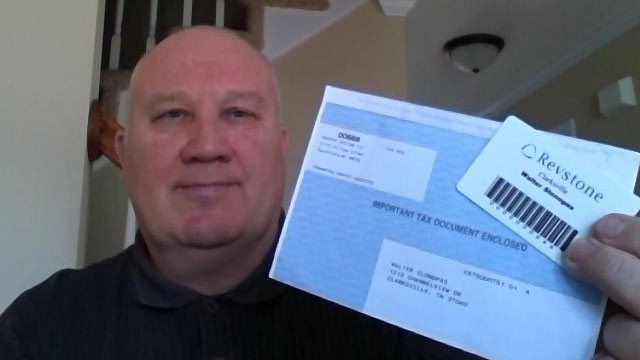 PHOTO: Walter Slonopas holds what he believes are signs of evil- his company identification card and W2 tax form.