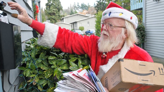 PHOTO: Postal carrier Bob McLean delivers mail, dressed as Santa, in Bellevue, Wash., in this 2009 file photo.