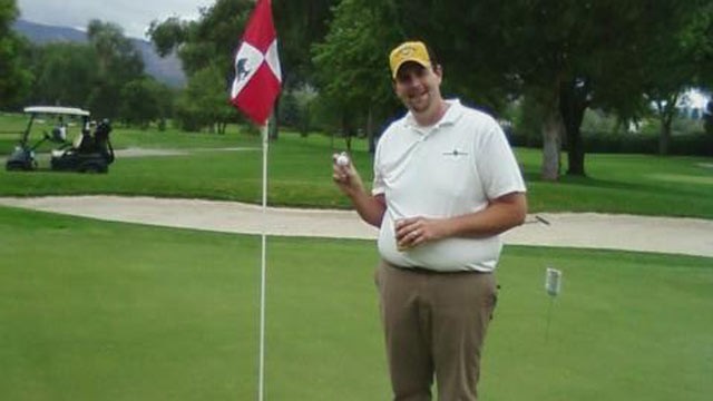 PHOTO: Troy Peissig taking the ball out of the hole after his hole-in-one shot for charity.