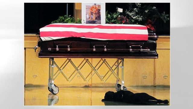 PHOTO: During the funeral for US Navy SEAL, Petty Officer Jon Tumilson, who was killed in a helicopter crash in Afghanistan earlier this month, his dog Hawkeye is shown lying next to his casket on the floor.