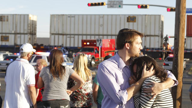 PHOTO: Bystanders react after a flatbed truck carrying wounded veterans and their families during a parade was struck by a train Thursday on Garfield in Midland.