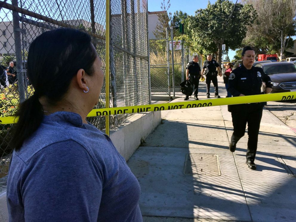 PHOTO: Gloria Echeverria watches as Los Angeles police officers close off a street where a shooting occurred at a middle school in Los Angeles, Feb. 1, 2018.