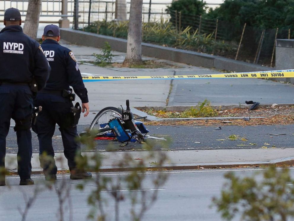 PHOTO: A New York Police Department officer stands next to a body covered under a white sheet near a mangled bike along a bike path, Oct. 31, 2017, in New York.