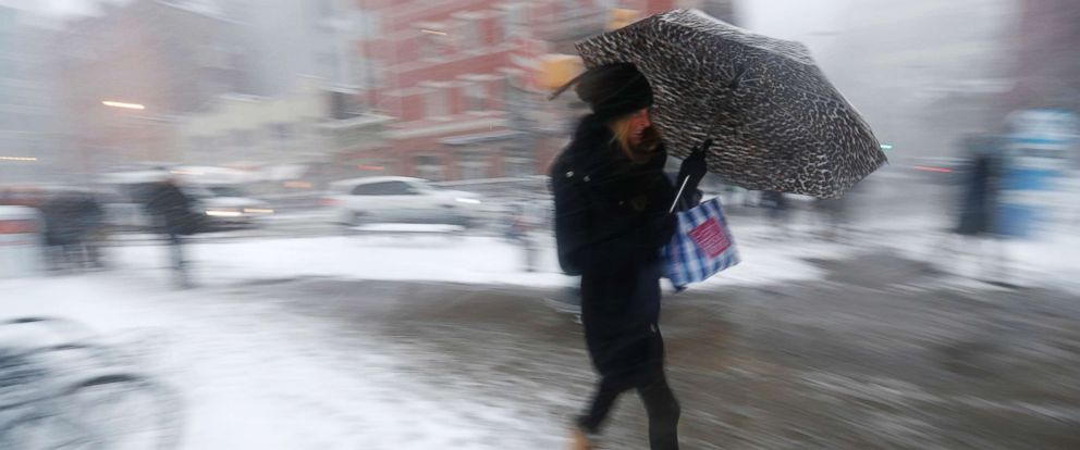 PHOTO: A woman uses an umbrella to shield herself from falling snow while approaching the Hoboken PATH train terminal, Feb. 9, 2017, in Hoboken, N.J. 