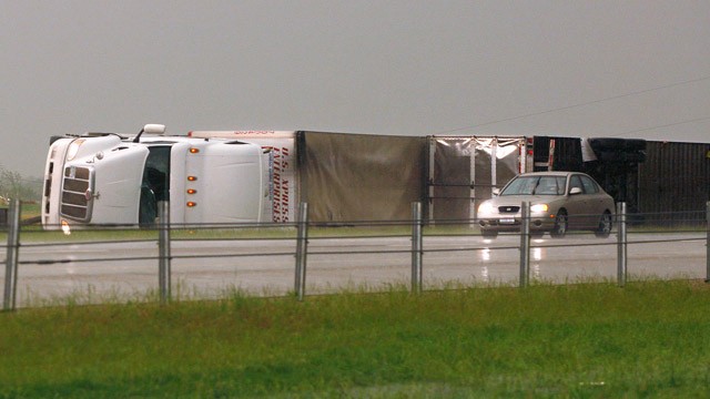 PHOTO: A car passes two semi tractor-trailers, flipped by a tornado, along I-40 eastbound just east of El Reno, Okla., May 31, 2013.