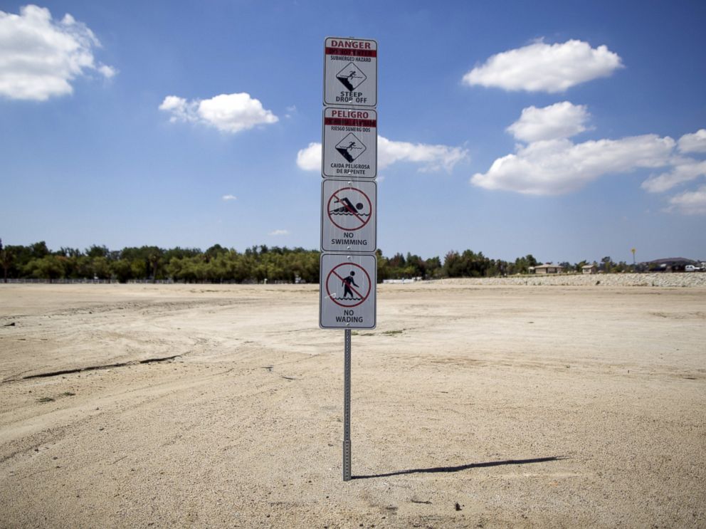 PHOTO: Signs warning of underwater hazards stand over a portion of dried up lake bed at Lake Elsinore in Lake Elsinore, Calif., July 23, 2015.