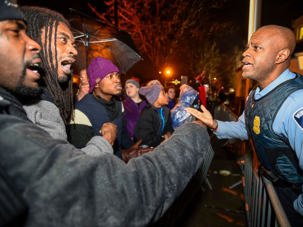 PHOTO: A police officer talks with demonstrators in front of a north Minneapolis police precinct during a protest in response to the shooting death of Jamar Clark by police officers in Minneapolis, Minnesota, Nov. 18, 2015.
